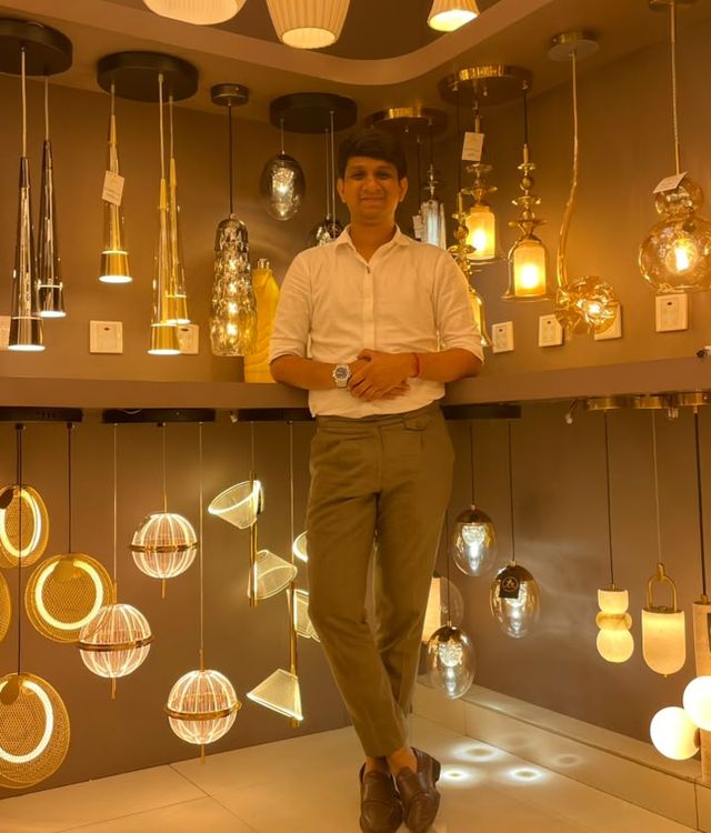 The owner of Art Lights standing in the Lohar Chawl showroom among pendant lights